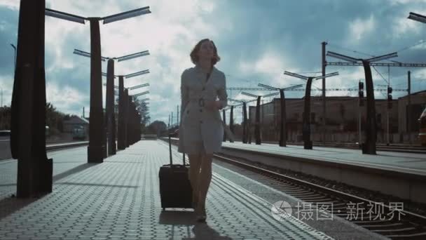 拍摄的女人提着行李步行穿过火车站