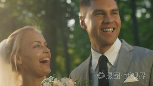 幸福的新婚夫妇，在一个阳光明媚的公园接吻