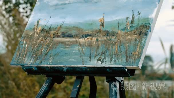 女手用油画颜料使用调色刀画水景观。4 k