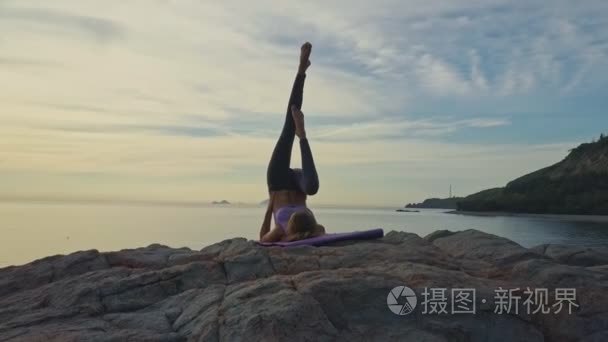 做瑜伽海洋岩石海岸的女孩视频