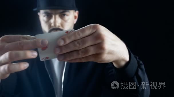 专业街魔术师帽在执行卡失踪的花招伎俩。背景是黑色