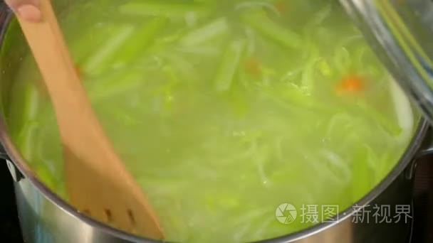 在一个锅里搅拌用草药汤