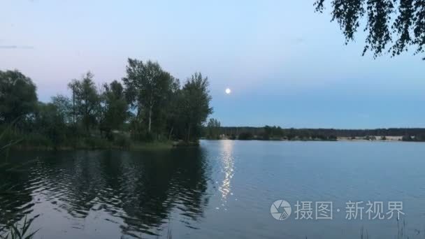 美丽的夜晚风景反对蓝色的湖视频