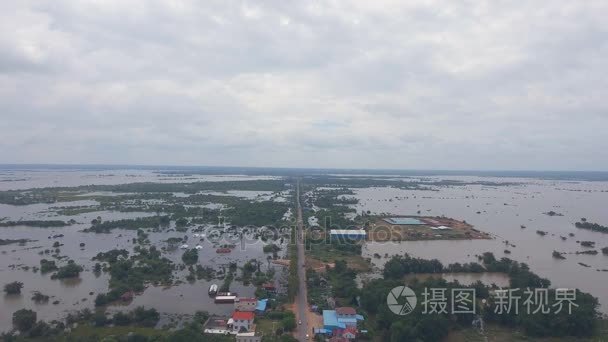 视图 在主干道上空飞行, 穿过一个淹没的村庄和田野