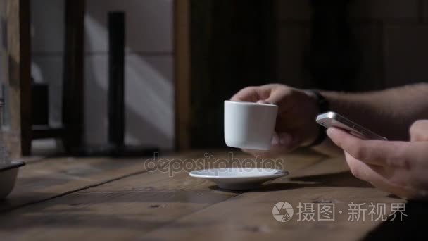 男人坐着智能手机同杯咖啡桌视频