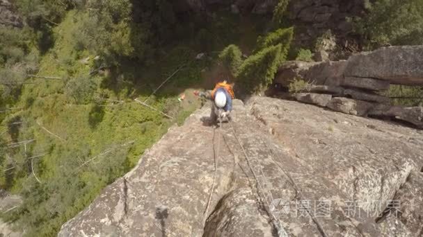 女孩的登山者攀登岩石峭壁视频
