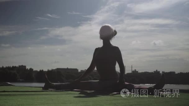 做瑜伽练习在河岸边的年轻女人视频