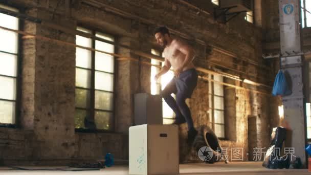 肌肉赤膊适合男人大力框跳在铁杆健身房做一部分的他穿越健身训练计划。人是从高强度的锻炼冒汗  锻炼，健身房位于风景如画废弃工厂位视频