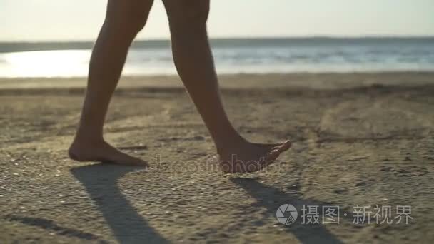 男子双腿走沙滩海滨日出快速慢动作关闭