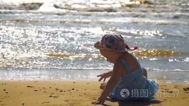 小女孩坐在沙滩上，在沙滩上画