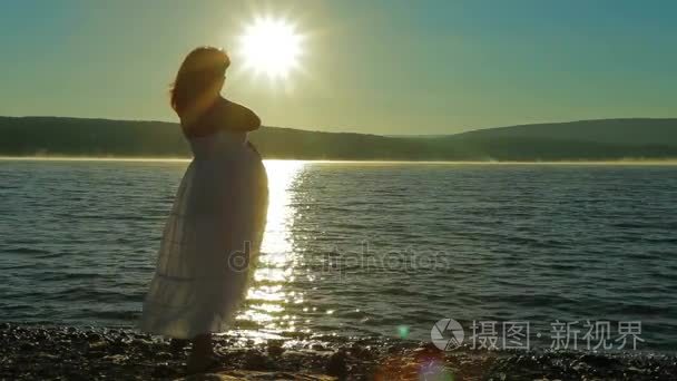 孕妇在沙滩上的迎接黎明视频