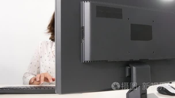 漂亮的商业女性在办公室电脑前工作时