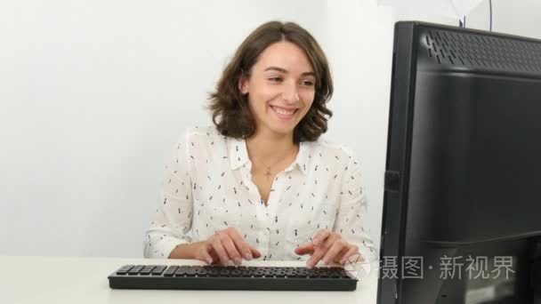 漂亮的商业女性在办公室电脑前工作时