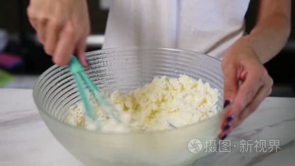 女性手准备面团混合面粉与在厨房里使用扫其他成分的特写视图。自制食品。慢动作镜头