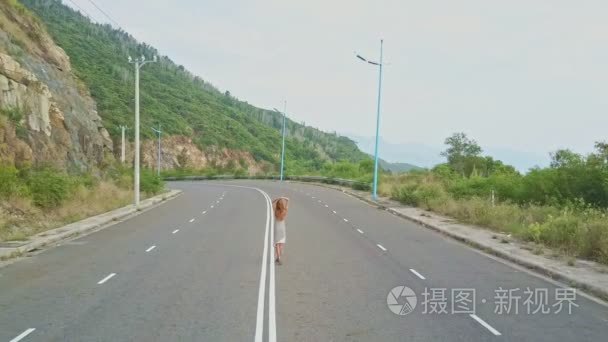 女孩漫步在空旷的公路视频