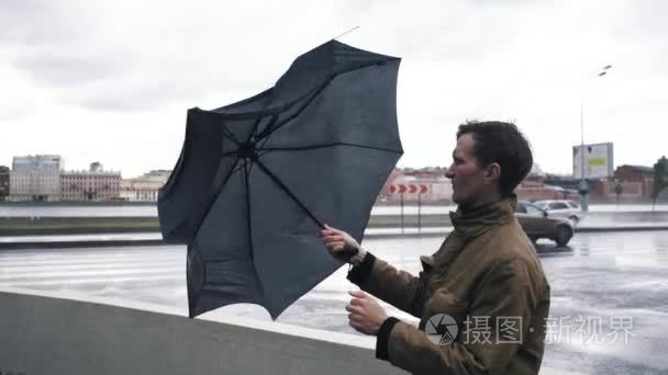 穿上雨伞的人。一阵风把雨伞从人手中拉了出来