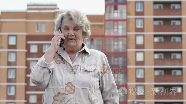 在户外使用智能手机的老妇会谈视频