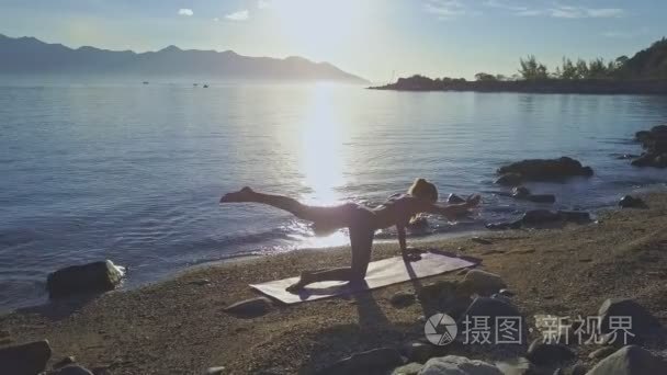 做瑜伽在沙滩海岸上的女孩视频