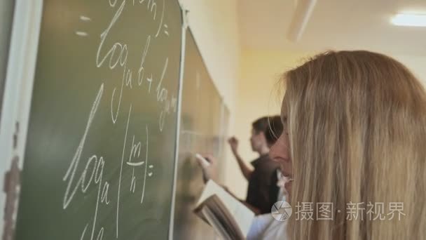 四个学生写上黑板在教室里的数学公式。俄罗斯学校