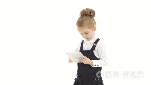 学校女孩一年级学生因在白色背景上的平板电脑进行通信视频