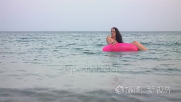 一个女人沐浴在大海与粉色圆圈视频