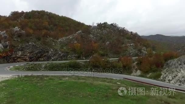 美丽的夏天山路。画面。一辆车行驶在盘山道上。新蜿蜒在山中