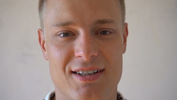 年轻男人微笑着看着相机在白色背景上孤立的特写.