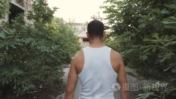 肌肉男走在拆除废弃的工厂视频
