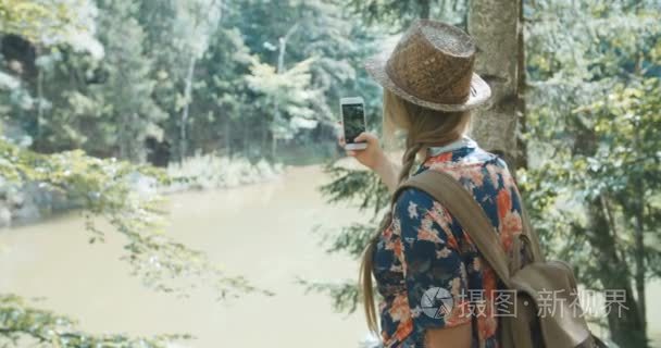 年轻女子在森林中使用手机视频