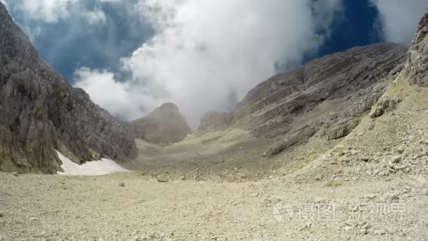 4 k.山与多变的天气中的延时 太阳和深云。走的人，且在附近徒步旅行。斯洛文尼亚，朱利安阿尔卑斯山，山谷，Bovec 区，影艺