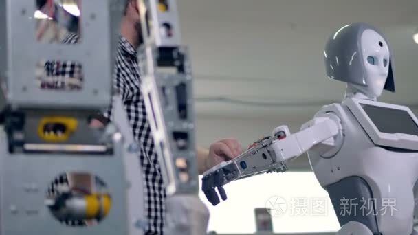 一位工程师降低机器人手臂收紧肩螺钉螺母。4 k