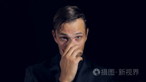 人抚摸着他的鼻子,看着镜头.谎言的手势短视频