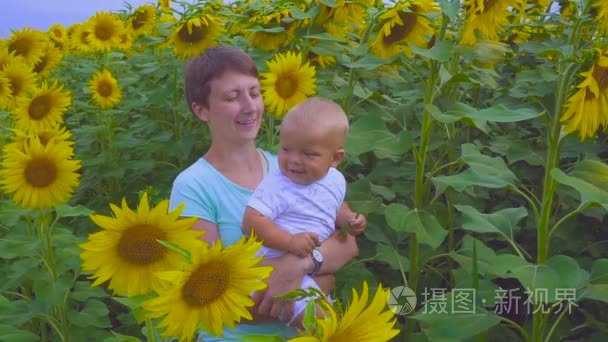 母亲和儿子玩一朵向日葵