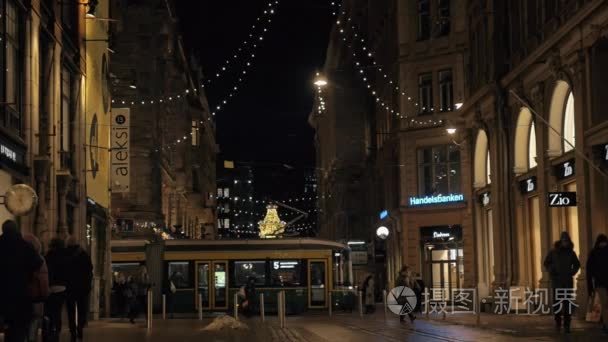与在傍晚散步人和传递电车街。芬兰赫尔辛基