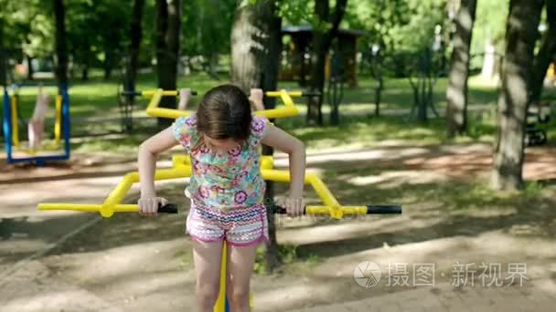 美丽的小女孩从事体育训练仪在夏天城市公园视频