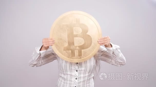 幸福的女人拿着金色的比特币视频