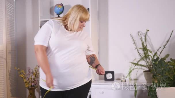 胖女人措施腰部和悲伤视频