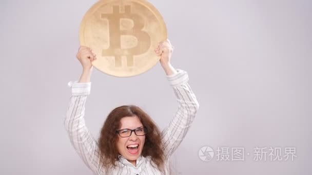 幸福的女人拿着金色的比特币视频