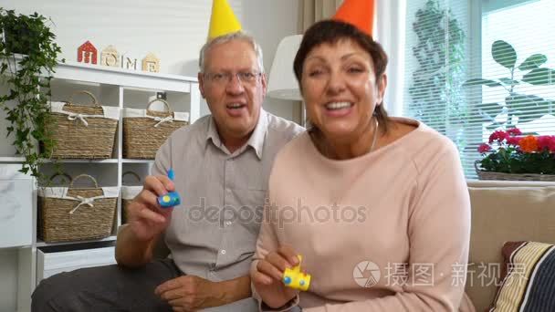幸福的爷爷和奶奶祝贺他们孩子快乐生日使用笔记本电脑视频通话