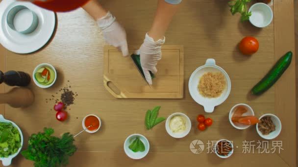 顶视图的女性手切黄瓜 西红柿 鱼 牛至 酱汁 奶酪