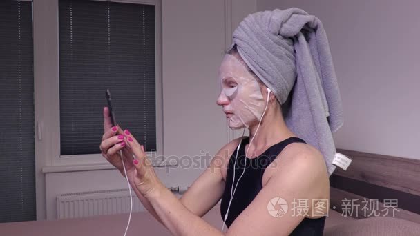 面膜使用智能手机的女人视频