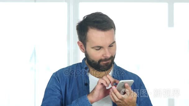 男人在办公室中使用智能手机，浏览互联网