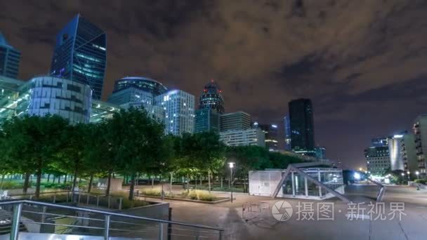 巴黎城市景观与现代建筑的商业区拉德芳斯游戏中时光倒流 hyperlapse 之夜。玻璃幕墙的摩天大楼。巴黎，法国