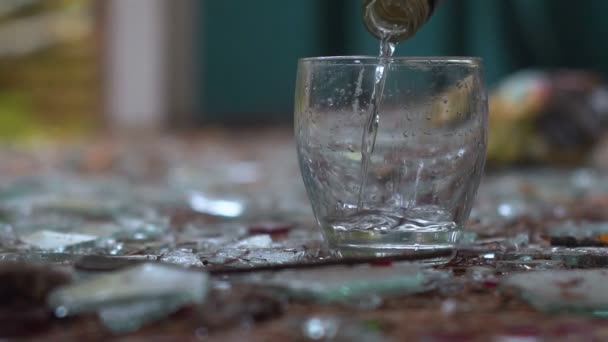 伏特加酒倒入一杯令人敬畏的背景上的碎玻璃