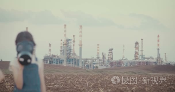 Save the planet. Kids wearing gas masks near an oil refinery