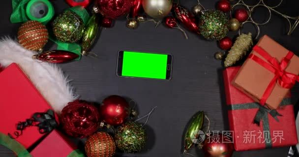 手触摸到智能手机屏幕之间圣诞装饰品