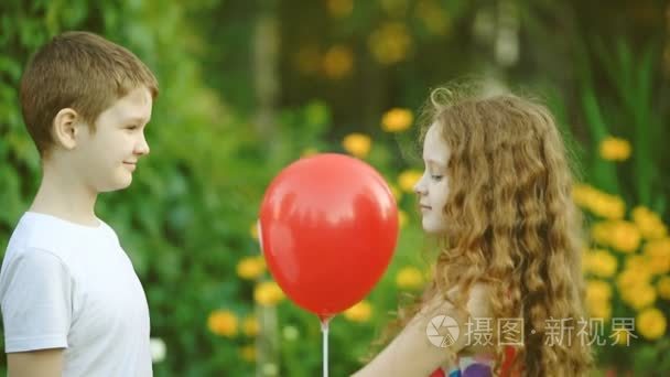 小男孩的礼物中夏公园的心与他的女朋友气球。情人节背景