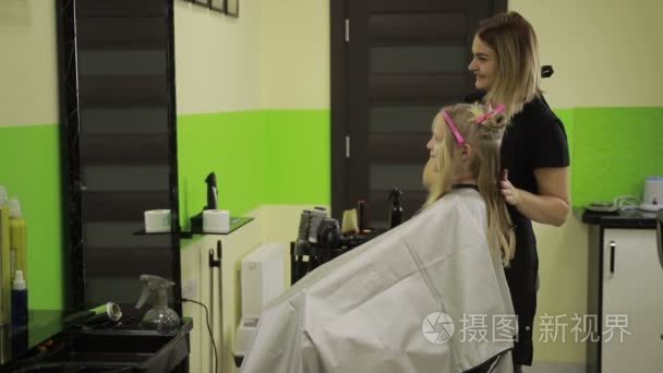 在美容美发梳女孩头发的理发师视频