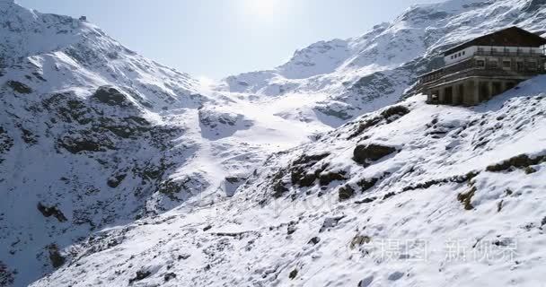 空中飞行在雪山岭谷附近旅馆制订向后移动。冬季室外雪高山野生自然景观。4 k 无人机飞行建立拍摄