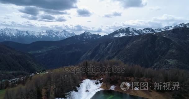 移动侧上面村庄和蓝色的湖到松落叶松森林森林和雪山在秋天。秋季阿尔卑斯山户外自然花葶山野生空中 establisher.4k 无人